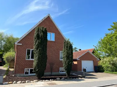 a red brick house with two trees in front of it at Cozy House Close to Beach and B&O in Struer
