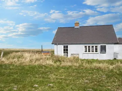 a white house with a black roof in a field at 10 person holiday home in Harboøre-By Traum in Harboør
