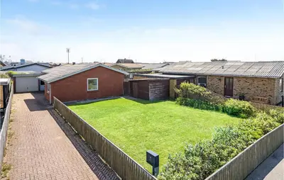 a backyard with a lawn in front of a house at Awesome Home In Thyborøn With Wifi in Thyborøn