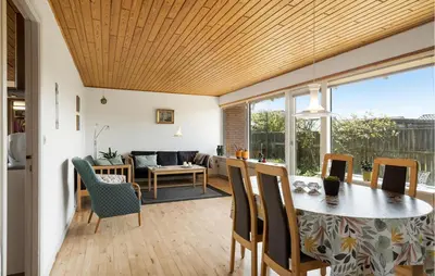 a dining room and living room with a table and chairs at Awesome Home In Thyborøn With Wifi in Thyborøn