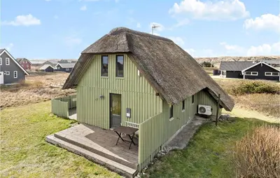 a small green building with a thatched roof at Awesome Home In Harboøre With Wifi in Harboør