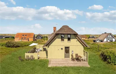a small yellow house with a roof on a field at Awesome Home In Harboøre With Wifi in Harboør