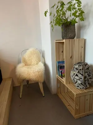 a furry chair sitting next to a wooden cabinet at Room 9 -Hawkraft kulturhotel in Vestervig