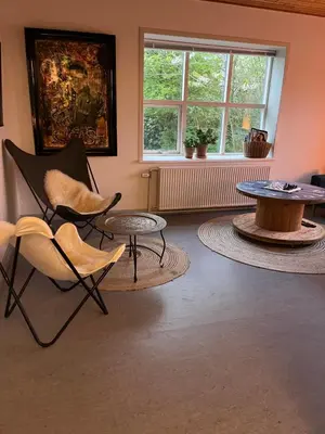 a living room with chairs and a table and a window at Room 9 -Hawkraft kulturhotel in Vestervig