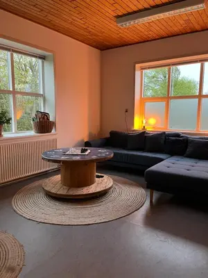 a living room with a table and a couch at Room 18 - Hawkraft kulturhotel in Vestervig