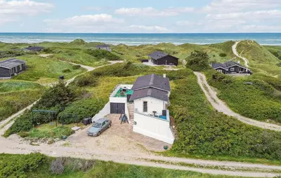 an aerial view of a house on a hill with the ocean at Stunning Home In Løkken With Sauna in Løkken