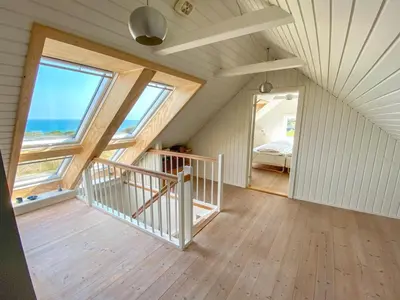 an attic room with a staircase and windows at Holiday Home Alkmar - 75m from the sea by Interhome in Thisted