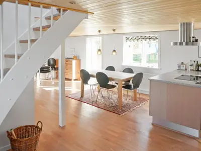 a kitchen and dining room with a table and chairs at Holiday Home Alkmar - 75m from the sea by Interhome in Thisted
