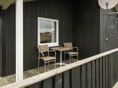 a porch with two chairs and a table and a window at Holiday Home Appollina - 400m from the sea by Interhome in Torsted