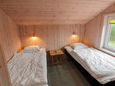 two beds in a room with a table at Holiday Home Appollina - 400m from the sea by Interhome in Torsted