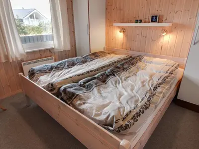 an unmade bed in a room with a window at Holiday Home Appollina - 400m from the sea by Interhome in Torsted