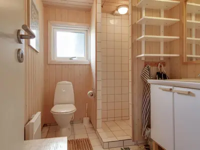 a small bathroom with a toilet and a sink at Holiday Home Eunike - 220m from the sea by Interhome in Løkken