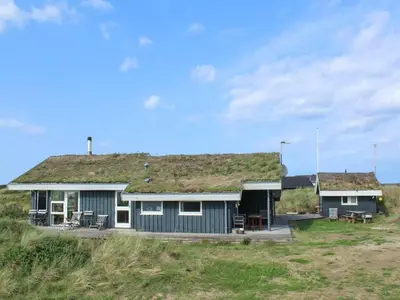 a house with a grass roof on the beach at Holiday Home Eunike - 220m from the sea by Interhome in Løkken