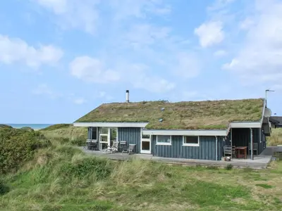 a house with a grass roof on the beach at Holiday Home Eunike - 220m from the sea by Interhome in Løkken