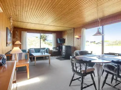 a living room with a couch and a table at Holiday Home Mira - 375m from the sea by Interhome in Løkken