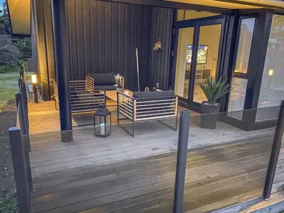 a porch of a house with a wooden deck at Holiday Home Telma - 200m from the sea by Interhome in Blokhus