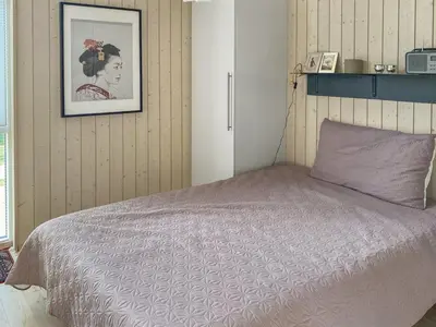 a bedroom with a bed and a picture on the wall at Holiday Home Telma - 200m from the sea by Interhome in Blokhus