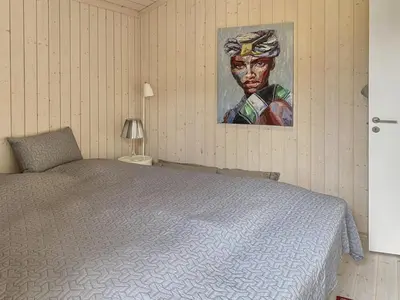 a bedroom with a bed and a painting on the wall at Holiday Home Telma - 200m from the sea by Interhome in Blokhus