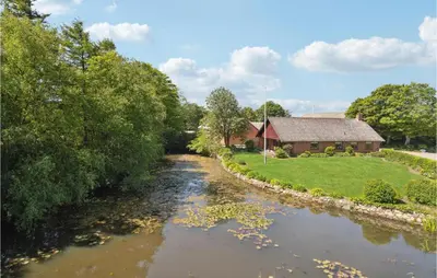 a river with a house in the background at Nice Home In Bækmarksbro With Wifi in Bækmarksbro