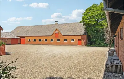a large red barn with a gravel driveway at Nice Home In Bækmarksbro With Wifi in Bækmarksbro