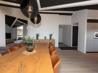 a large wooden table with chairs and a vase on it at 10 person holiday home in Saltum-By Traum in Saltum