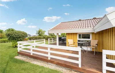 a house with a white fence and a deck at 3 Bedroom Gorgeous Home In Farsø in Farsø