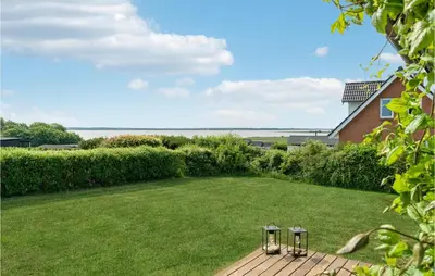 a garden with two chairs in the grass at 3 Bedroom Gorgeous Home In Farsø in Farsø