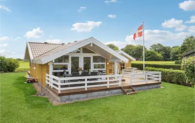 a small house with a porch and a flag at 3 Bedroom Gorgeous Home In Farsø in Farsø