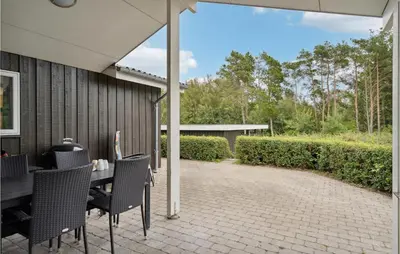 an outdoor patio with a table and chairs at Cozy Home In Farsø With Sauna in Farsø