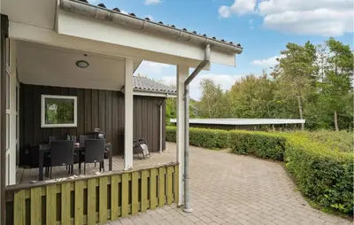 a patio with a table and chairs on a house at Cozy Home In Farsø With Sauna in Farsø