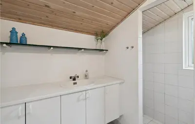 a bathroom with white cabinets and a sink at Cozy Home In Farsø With Sauna in Farsø