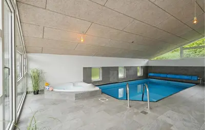 a swimming pool with a tub in a house at Cozy Home In Farsø With Sauna in Farsø