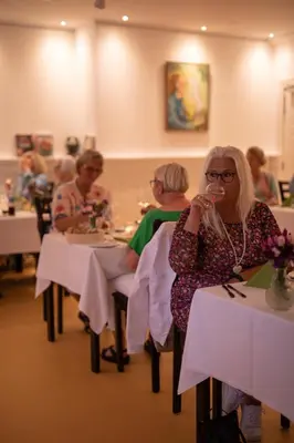 a group of people sitting at tables in a restaurant at Skovsgård Hotel in Brovst