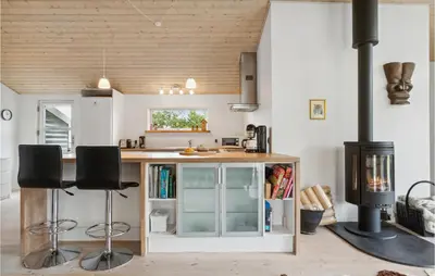 a kitchen with a stove and a counter with stools at Pet Friendly Home In Saltum With Wifi in Saltum