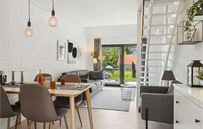 a kitchen and living room with a table and chairs at Nice Apartment In Blokhus With Wifi in Blokhus