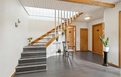 a hallway with stairs and a chair in a house at Beautiful Home In Farsø With Kitchen in Farsø