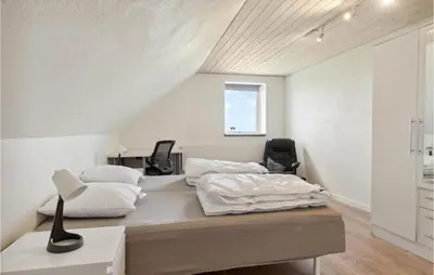a bedroom with a bed and a desk and chairs at Beautiful Home In Farsø With Kitchen in Farsø
