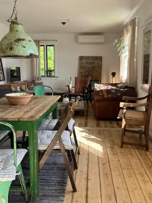 a living room with a green table and chairs at The Old Soap House - stylish and close to beach in Vang