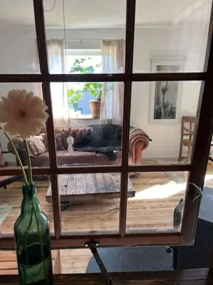 a view of a living room through a glass window at The Old Soap House - stylish and close to beach in Vang