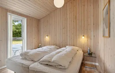 a bedroom with a bed with white pillows on it at Gorgeous Home In Fjerritslev With Sauna in Fjerritslev