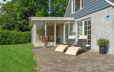 a patio with three chairs and a house at Amazing Home In Vesløs in Øsløs