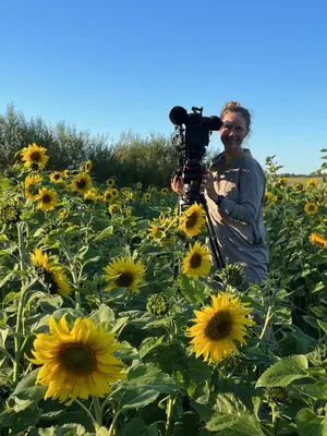 a man holding a camera in a field of sunflowers at Room 14 - Hawkraft kulturhotel in Vestervig