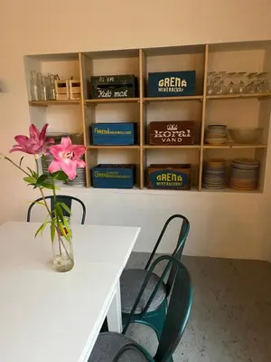 a table and chairs with a vase of flowers on a table at Room 14 - Hawkraft kulturhotel in Vestervig