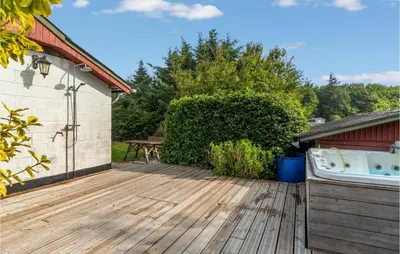a wooden deck with a bath tub next to a building at Beautiful Home In Struer With Kitchen in Struer
