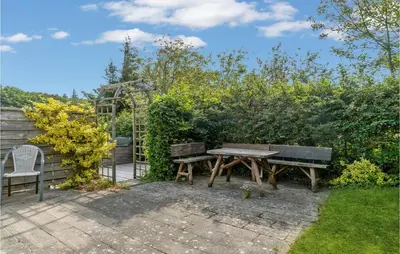 a picnic table and chairs in a garden at Beautiful Home In Struer With Kitchen in Struer