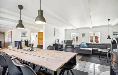 a living room with a large wooden table and chairs at Beautiful Home In Thyborøn With Sauna in Thyborøn