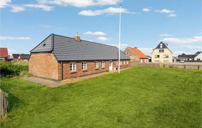 a brick house with a grass yard in front of it at Beautiful Home In Thyborøn With Sauna in Thyborøn