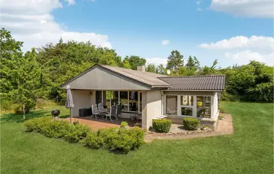 a small house with a patio in a yard at Cozy Home In Spøttrup With Wifi in Spottrup