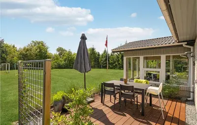 a patio with a table and an umbrella at Cozy Home In Spøttrup With Wifi in Spottrup