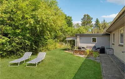 a yard with two chairs and a table and a patio at Cozy Home In Spøttrup With Wifi in Spottrup